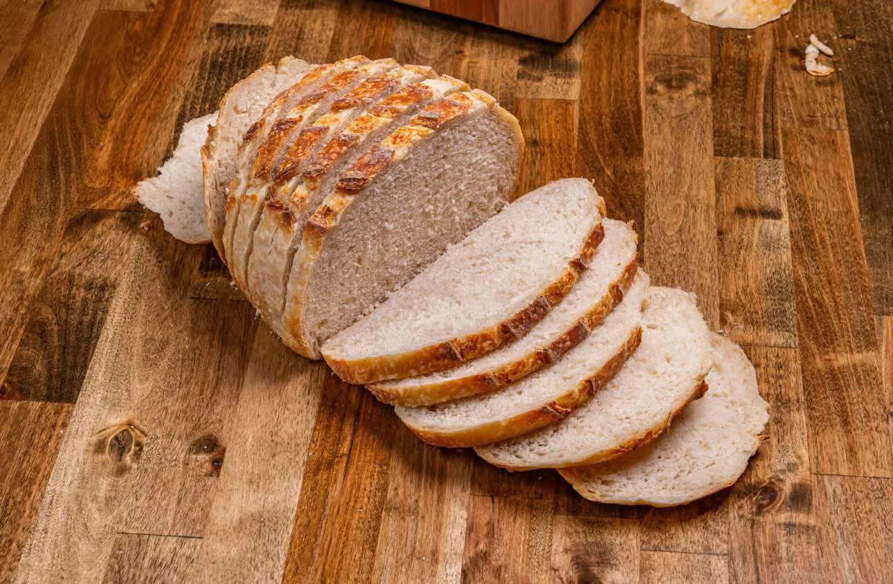 Sliced Sour Boule sourdough loaf on a wooden worktop